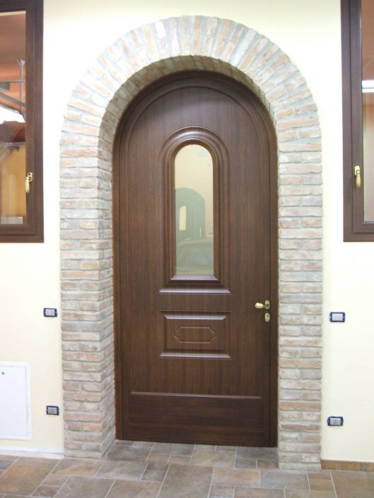 Porta su misura in legno sotto un arco